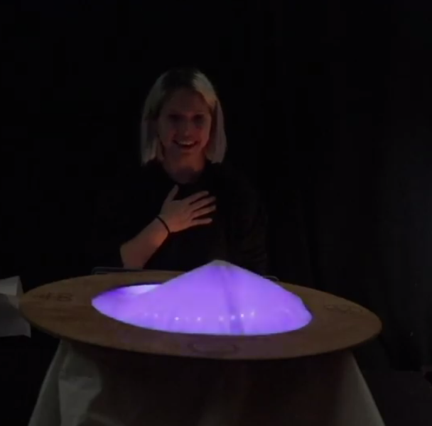 a woman looking surprised at a glowing box