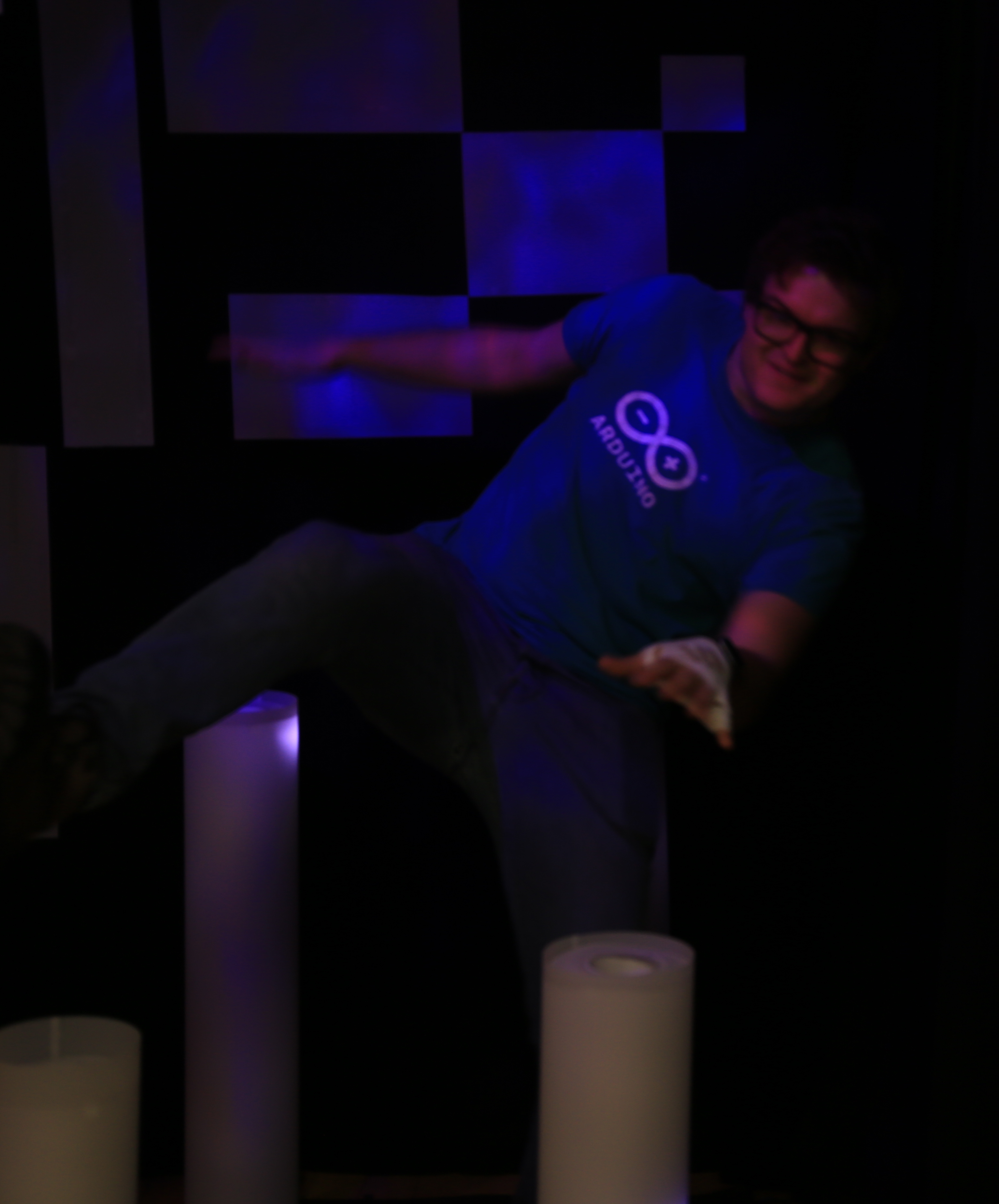 a man trying to balance on one leg over some glowing tubes